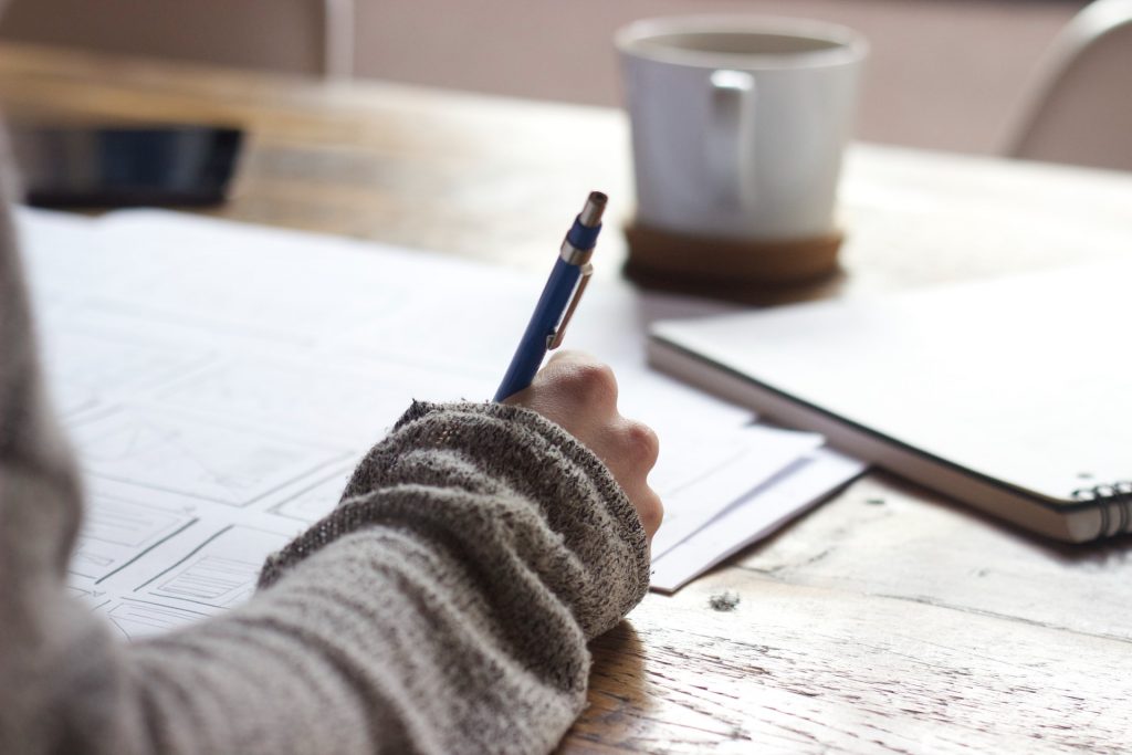 Une personne écrit sa stratégie de content marketing